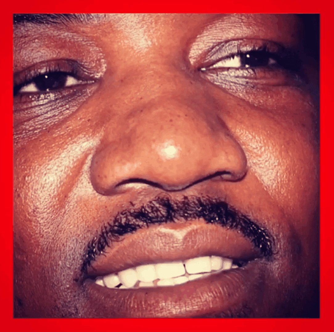 Close-up of a smiling man's face with a red border.