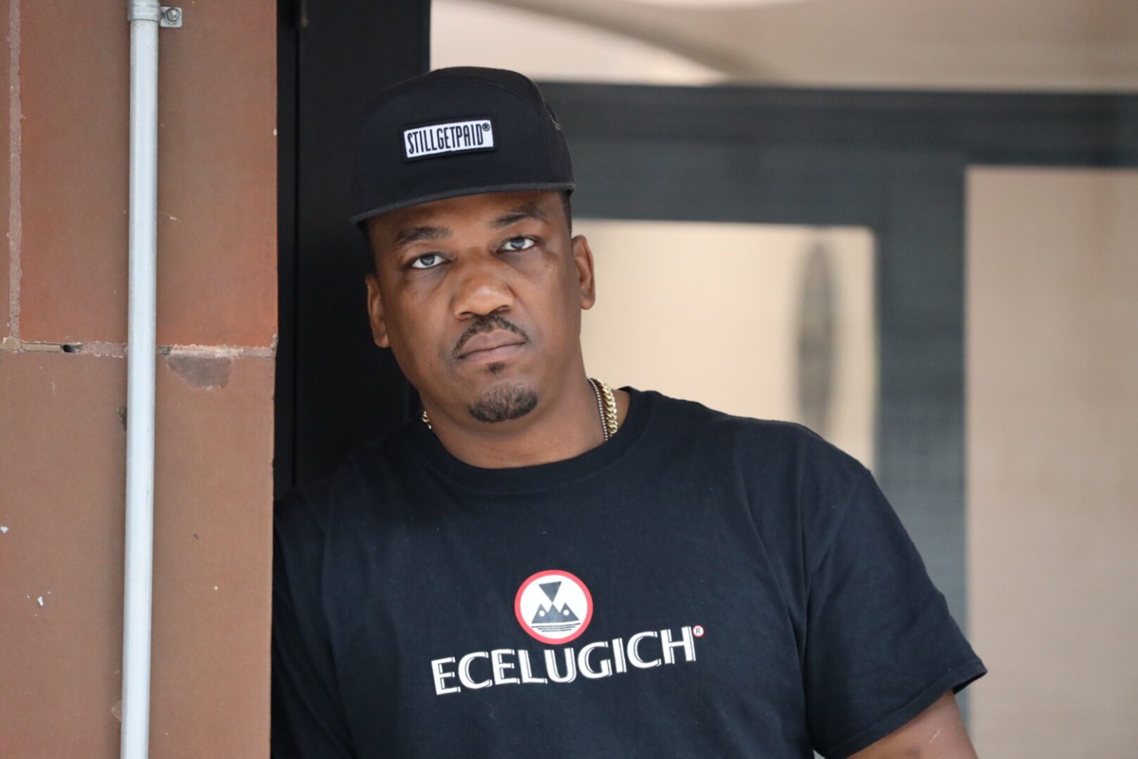 Serious expression wearing gold chain and t-shirt
